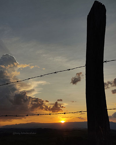 Foto de uma cerca no pôr do sol sem edição